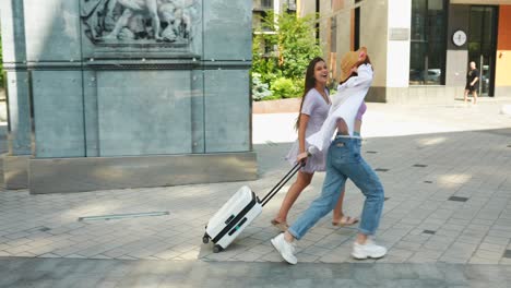 two women running through the city with luggage