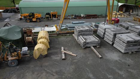 concrete building slabs and heavy construction machinery in site, aerial