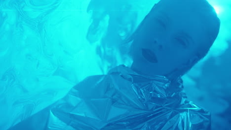 alien woman in silver gown posing in laser light