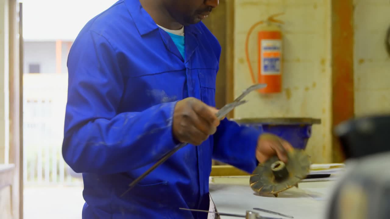Worker using caliper at table in foundry workshop 4k