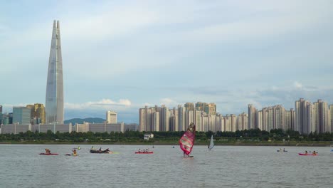 Menschen,-Die-Wasseraktivitäten-Am-Fluss-Han-Genießen,-Mit-Blick-Auf-Die-Skyline-Von-Seoul-Und-Den-Wolkenkratzer-Lotte-World-Tower-In-Südkorea