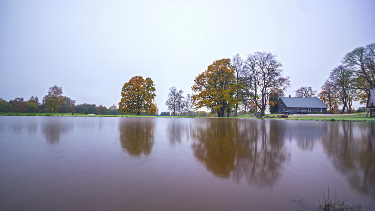 평온한 호수는 겨울 시즌까지 안개가 가득한 일출에 반사됩니다.