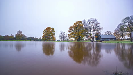 Calm-Lake-With-Reflections-On-A-Foggy-Sunrise-Until-Winter-Season