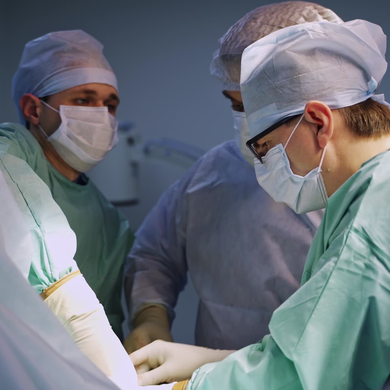 Group of experienced surgeons working at operation. Focused doctors collaborating at surgery