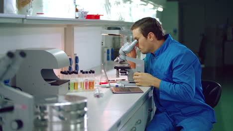 químico masculino en un laboratorio químico. científico de química buscando un microscopio