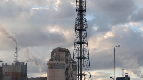 el humo que sale de las chimeneas de una planta de fertilizantes al atardecer en rumania