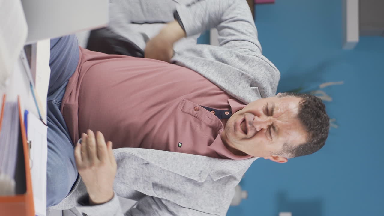 vídeo vertical de un anciano trabajador de la oficina en casa con picazón por alergias.