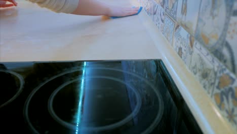 female hands wipe the kitchen surface with a rag