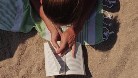 person reading a book on the beach