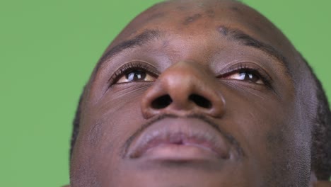 close up shot of young african man thinking while looking up