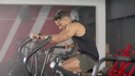 exercising on stationary bike, man focusing on intense cardio workout in gym