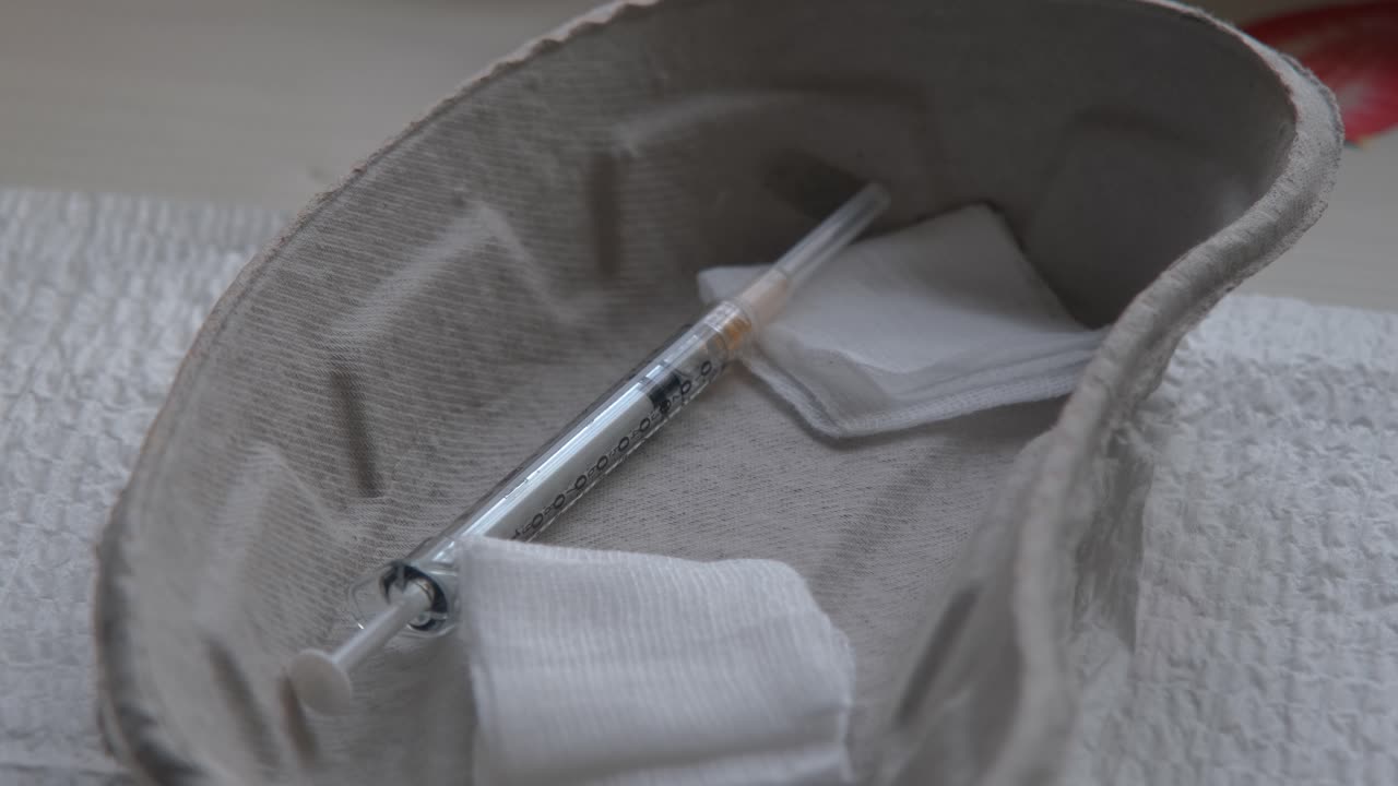 En nål med en dos av COVID-19-vaccinet ligger redo i en steril skål i väntan på att administreras.
