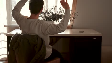 happy laid back man putting hands on head, relaxing and pondering at desk