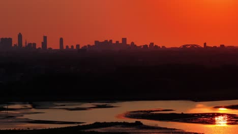 Vista-Cinematográfica-De-La-Puesta-De-Sol-Sobre-El-Horizonte-De-La-Ciudad-A-Lo-Largo-Del-Río-Noord-En-Rotterdam,-Países-Bajos