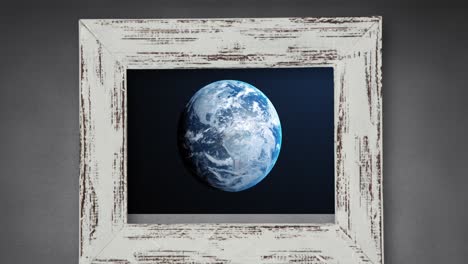 animation of globe in wooden frame on grey background