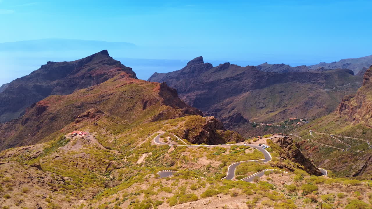 Flight over the rock with a wavy road on top. Mountainous landscape of Tenerife, the Canary Islands, Spain
