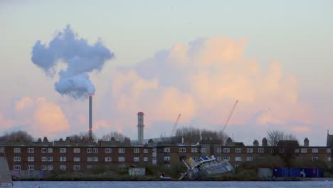 Townscape-of-brick-houses-factory-pipes-and-shipwreck-in-golden-hour