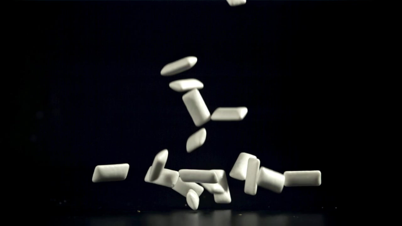 Pezzi di chewing gum bianchi che cadono al rallentatore