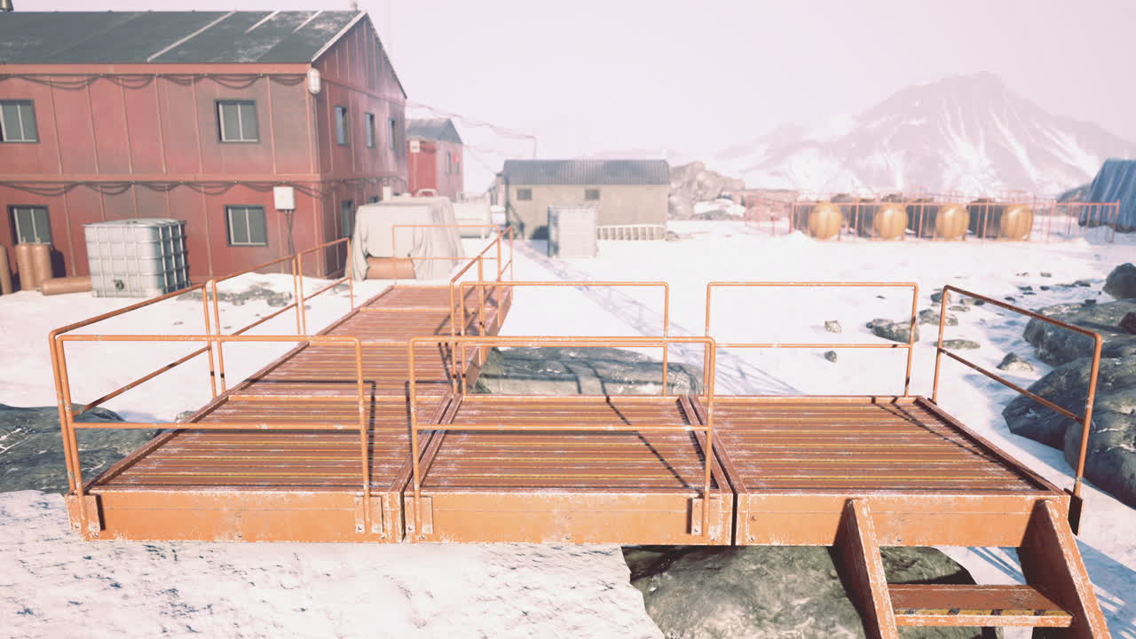 Bright orange bridge connecting buildings in snowy remote location