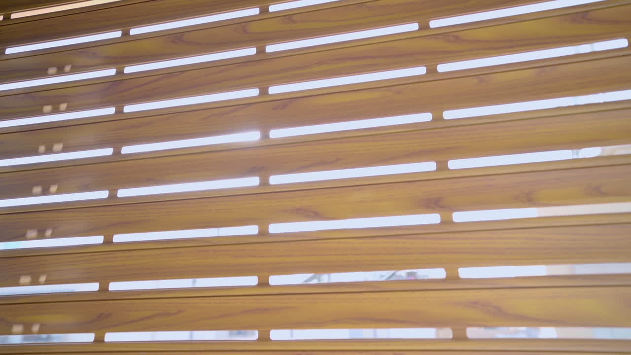 The morning sun shines through a partially open window, casting a warm sunrise glow through the blinds