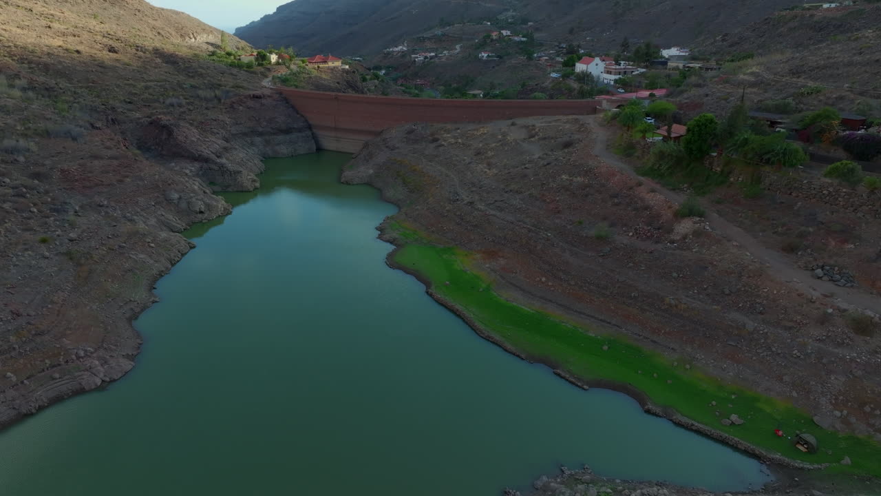presa de ayagaures, gran canaria: fantástica vista aérea viajando a lo largo de la pared de contención de la presa en un día soleado y en un entorno natural privilegiado