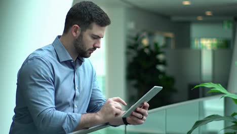 focused young businessman using digital tablet in modern office
