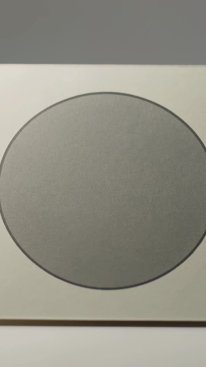 Video verticale: Movimento di camera che rivela la carta in cima a un mazzo su un tavolo da studio, centrando un cerchio grigio