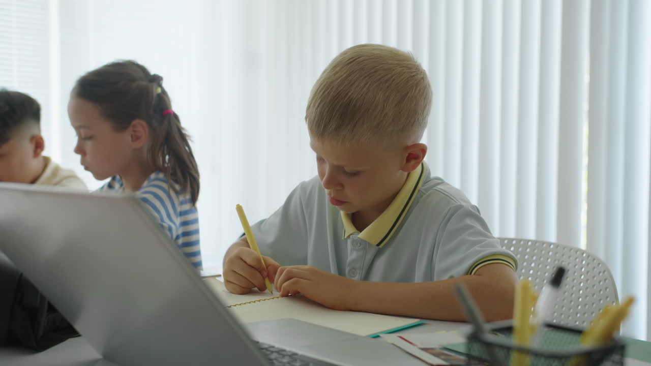 Small Pupil Doing Test during Group Class at School