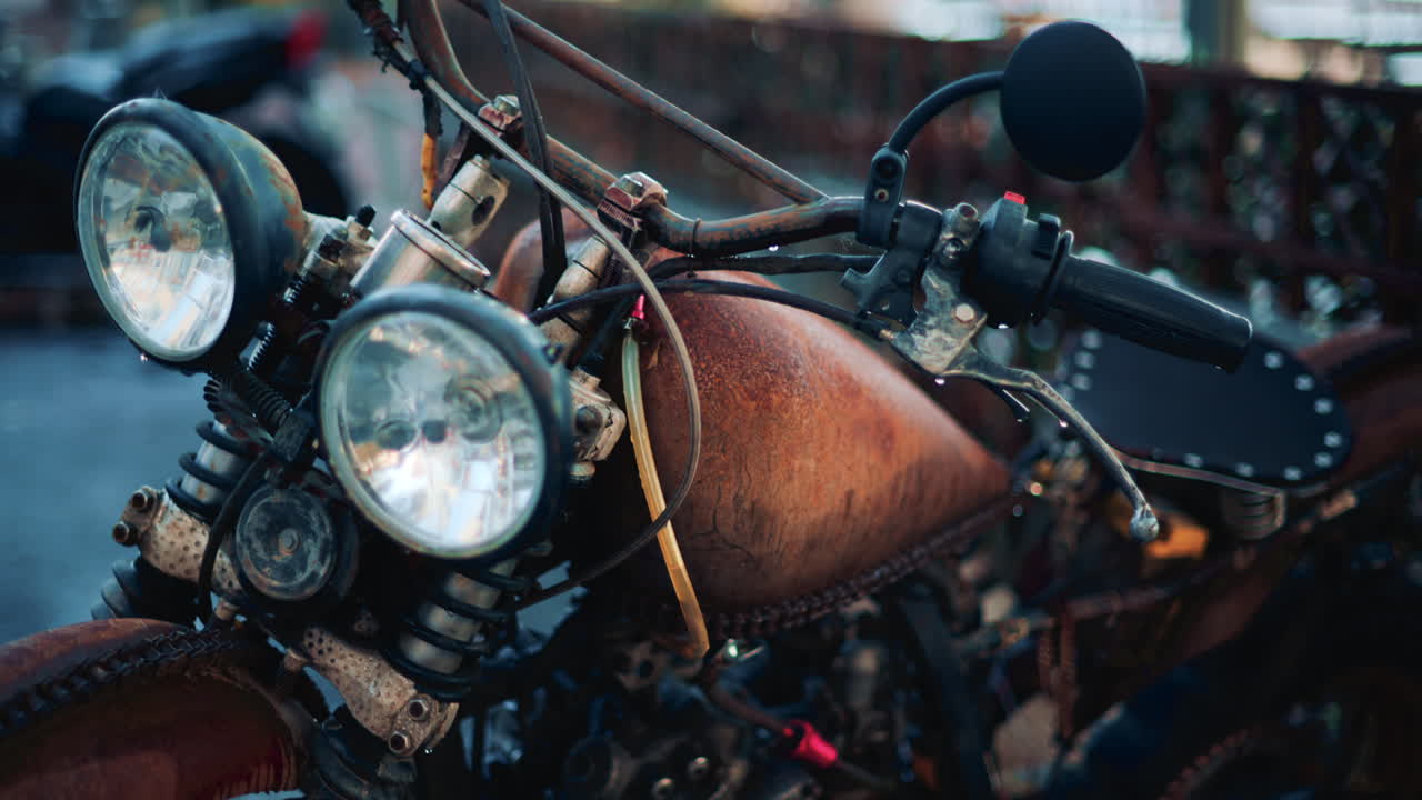 Close up of a vintage rusty motorcycle parked on a city street