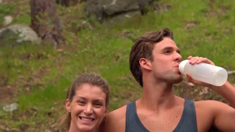 smiling couple taking a break while jogging