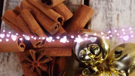 Animation-of-heart-string-lights,cinnamon-sticks-and-christmas-decorations