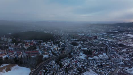 tonsengagen bjerke arvoll oslo norge norway aerial drone morning neighborhood apartment condominiums buildings cars traffic snowing snow flakes cold cloudy winter day gray skies city forward motion