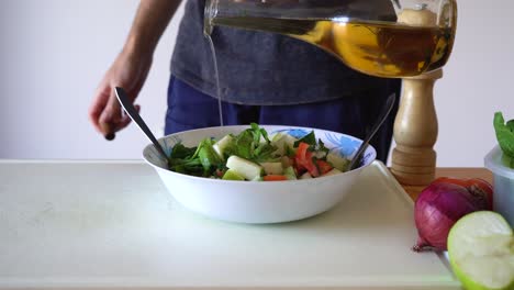 verter aceite de oliva en un plato de ensalada para el desayuno