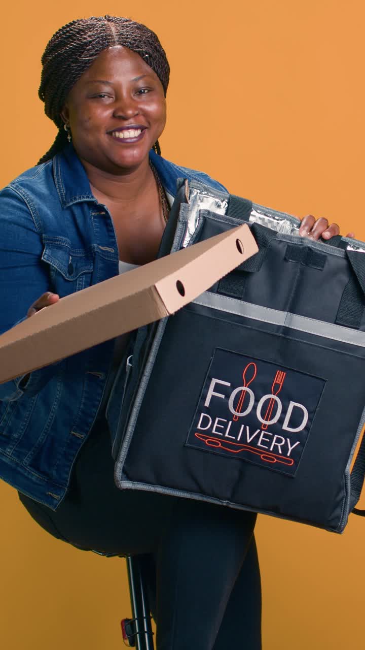 A woman with a delivery bag and a cardboard box