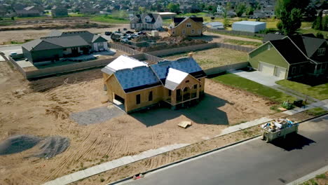 una foto de un dron girando alrededor de una nueva casa a punto de poner tejas en el techo