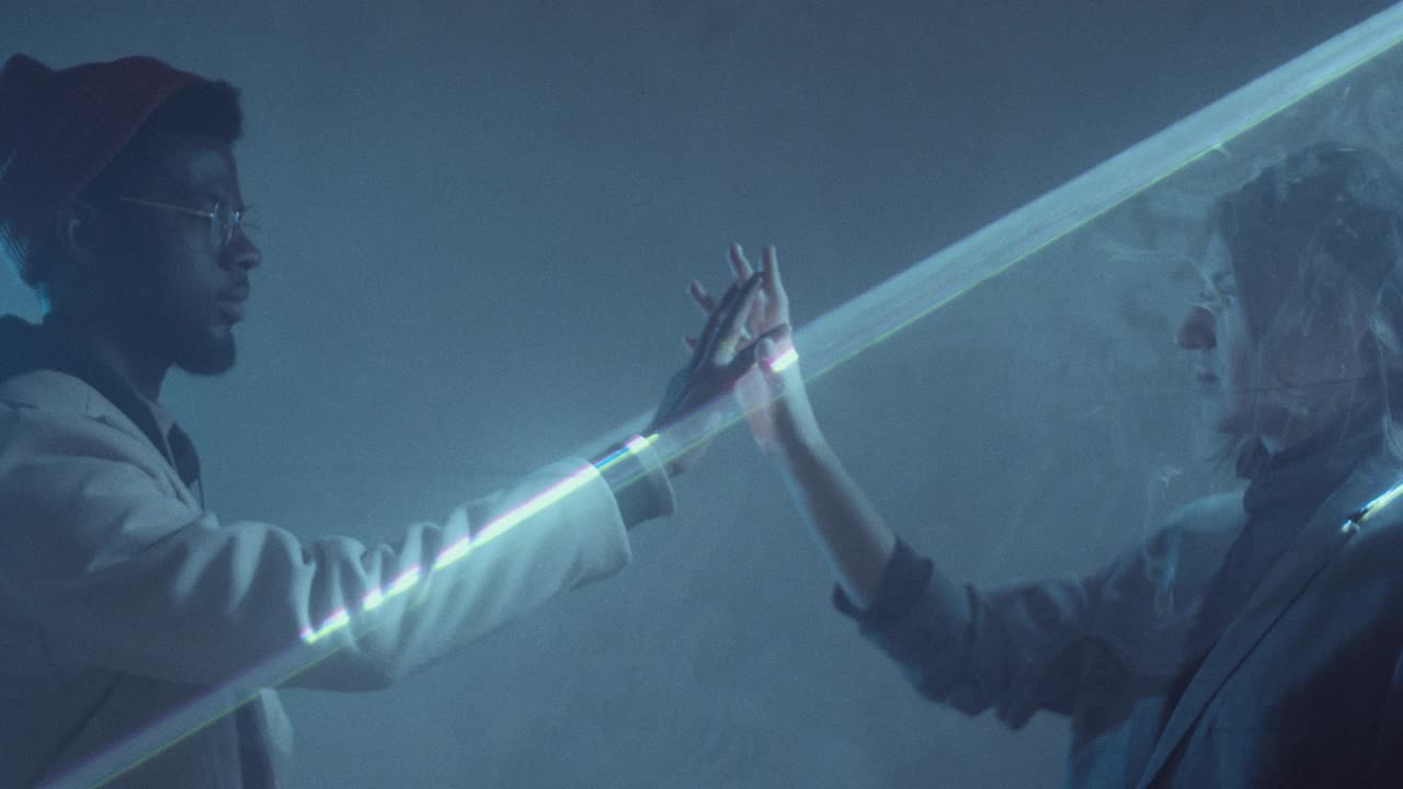 hombre y mujer diversos tomados de la mano en la proyección de luz láser