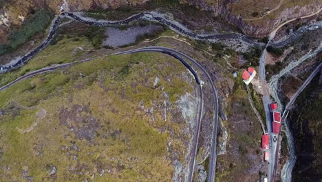 an aerial shot of a train going around the "nariz del diablo" or devil's nose in alausí, chimborazo province, ecuador