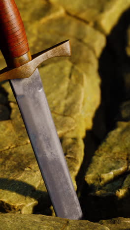 un primer plano de una espada medieval en una piedra