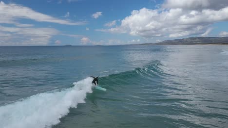 Unrecognizable-and-isolated-surfer-surfing-wave-at-Emerald-beach,-Australia