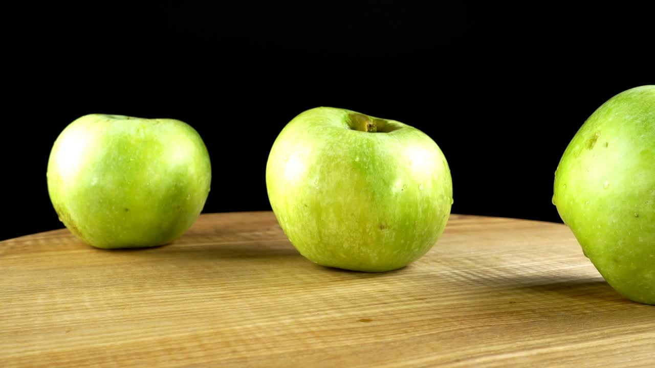 Æbler på sort baggrund. Skærebræt i bevægelse.