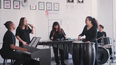 estudiantes de la escuela de artes escénicas tocando en la banda en el ensayo