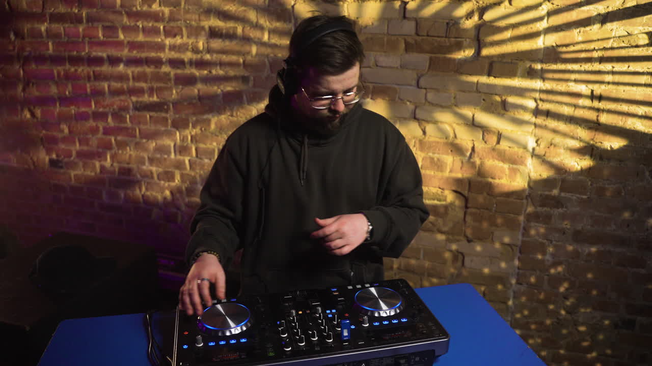 hombre con gorra negra pinchando en la discoteca.