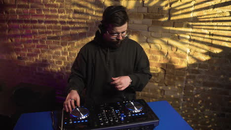 man with black cap djing at the disco