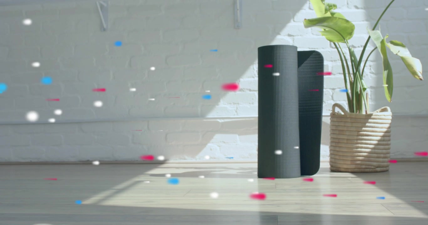 Digitala partiklar dyker upp vid vänster kant och glider över mattor och en växt, vilket avslöjar en träningshörna.