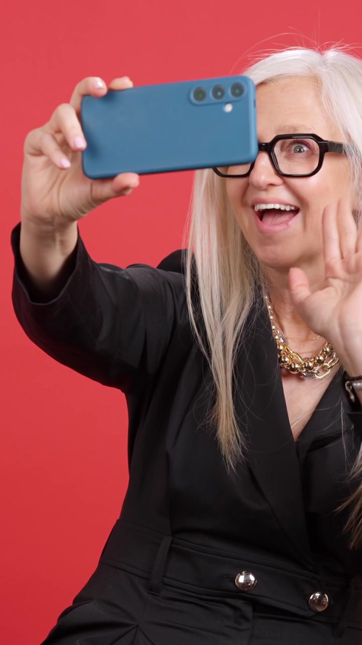 Elegant mature woman taking a selfie with a smartphone