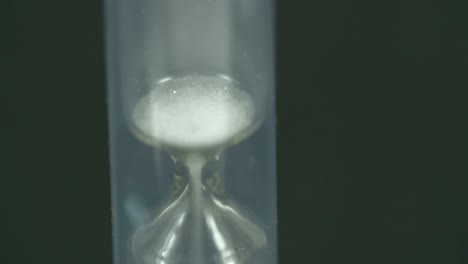 the last drops of sand are dropping in the hourglass