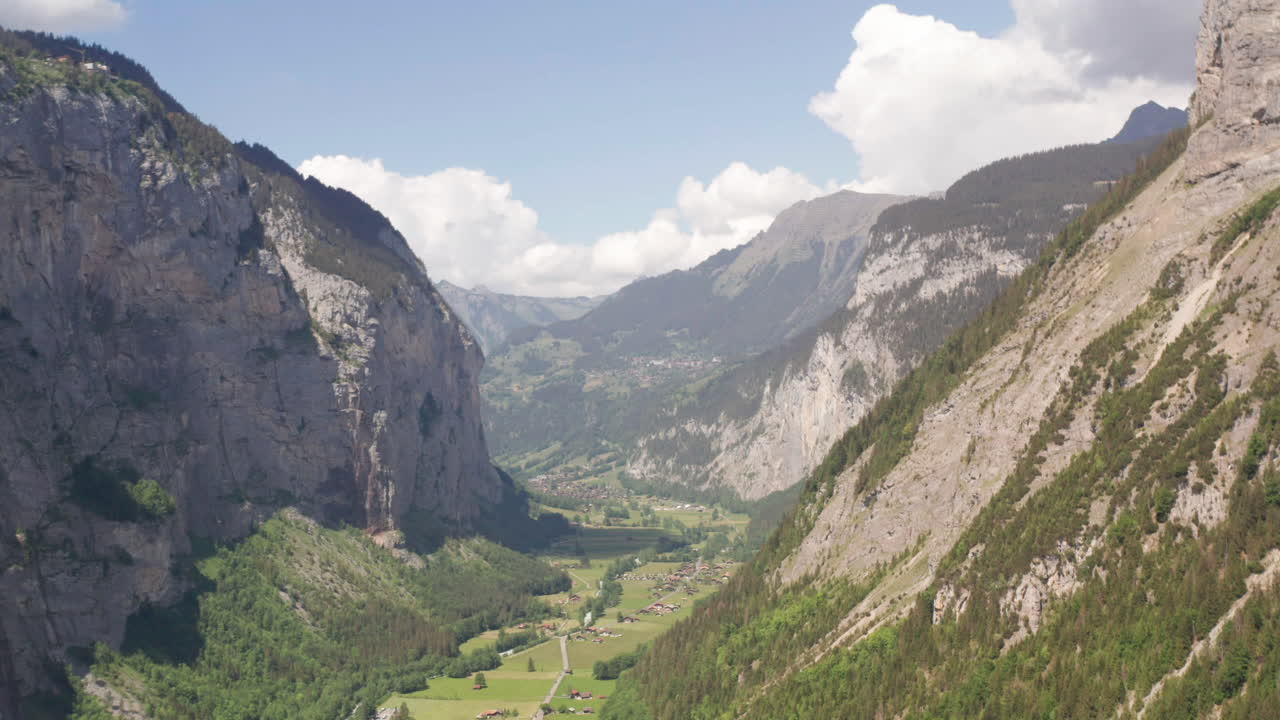 Aerial dolly of beautiful green valley surrounded by mountains in summer