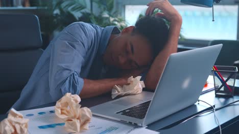 young african american man lays head on desk and falls asleep sits in office