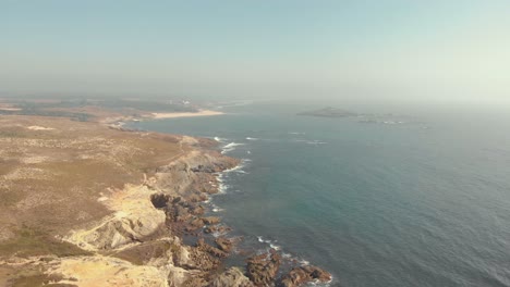 flying over the mainland, towards the ocean, of porto covo in portugal