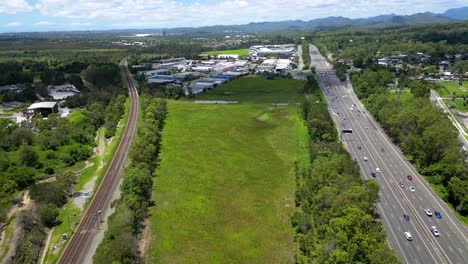 Vista-Aérea-En-Movimiento-Hacia-Adelante-Sobre-El-área-Industrial-De-Worongary,-M1-Y-Línea-Ferroviaria-Cerca-Del-Desarrollo-De-Skyridge,-Gold-Coast,-Queensland,-Australia